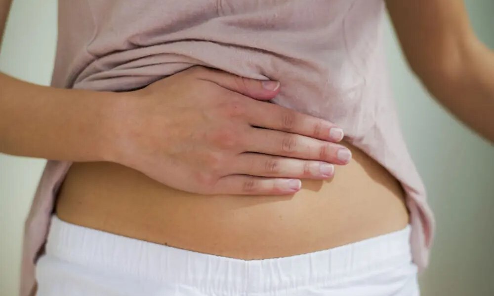 Close up of woman's hand placed on her stomach.