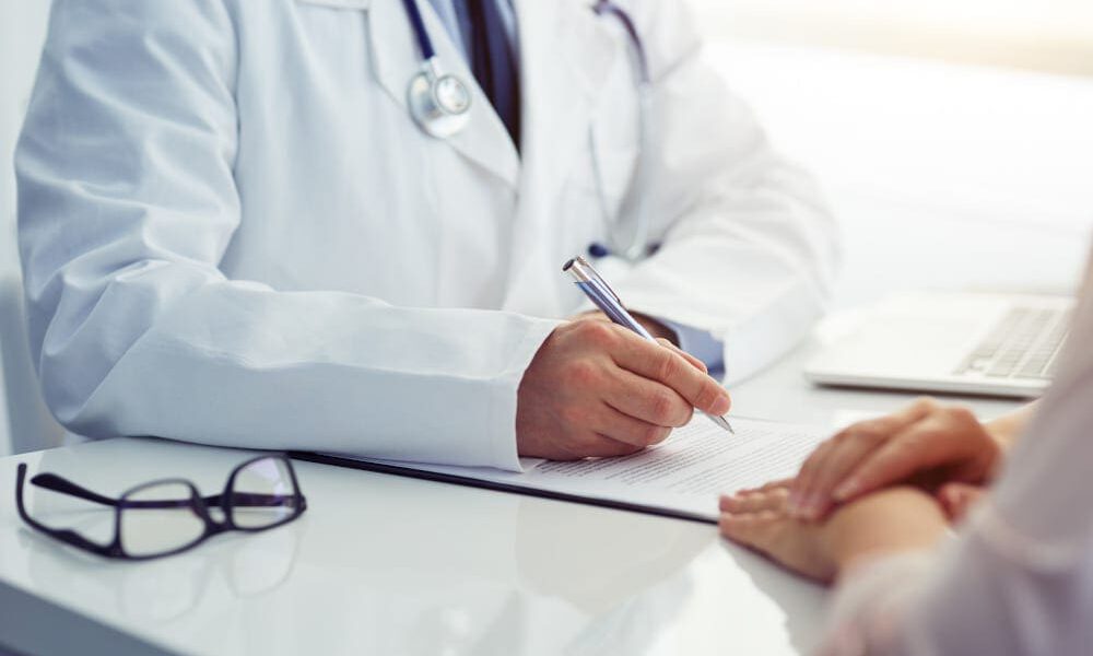 Male doctor and female patient talking at consultation.