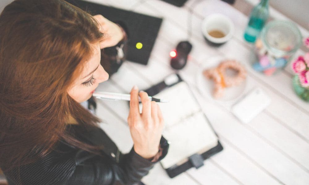 Overhead view of woman with red hair writing out a schedule